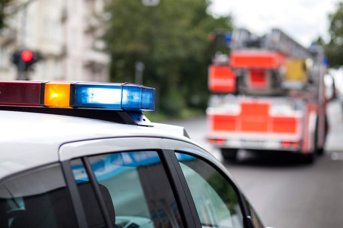 Police car and fire engine truck at the place of action - flashing bluelight, siren - selective focus