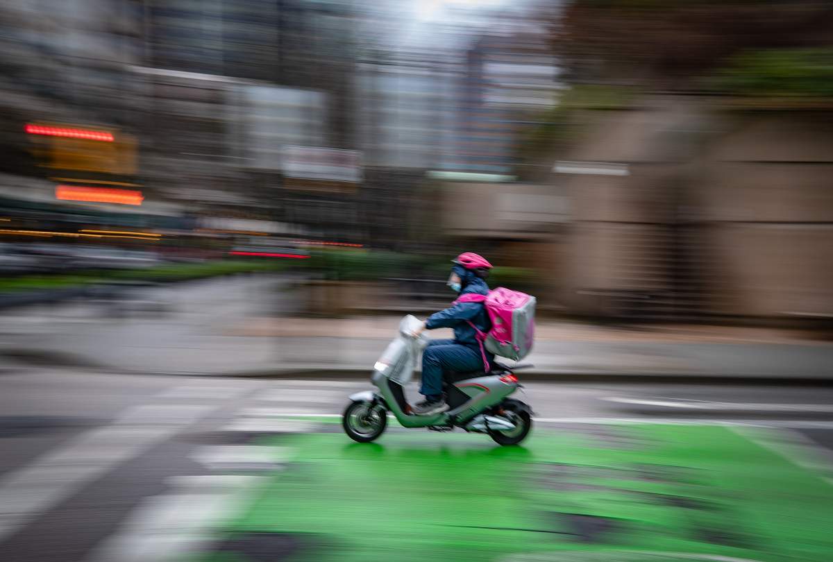 A food delivery worker rides an electric bike in downtown Vancouver.