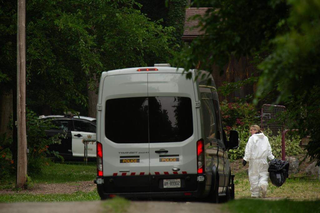 Members of the Ontario Provincial Police investigate the deaths of four people in Harrow, Ont., on June 21, 2024. Ontario Provincial Police say a mother and her two children found dead in their home near Windsor, Ontario last month were all fatally shot.