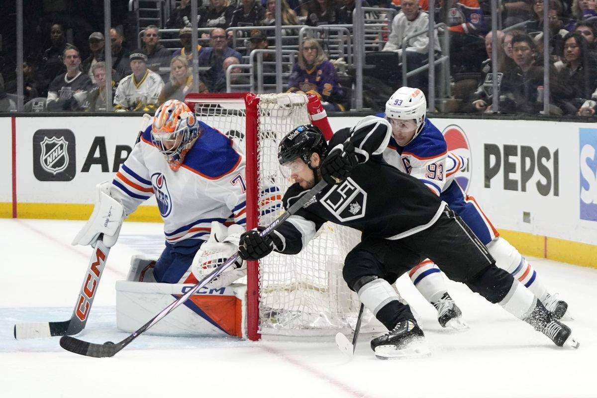 Los Angeles Kings right wing Viktor Arvidsson, centre, tries to get a shot past Edmonton Oilers goaltender Stuart Skinner, left, as centre Ryan Nugent-Hopkins defends during the second period in Game 4 of an NHL hockey Stanley Cup first-round playoff series Sunday, April 28, 2024, in Los Angeles.