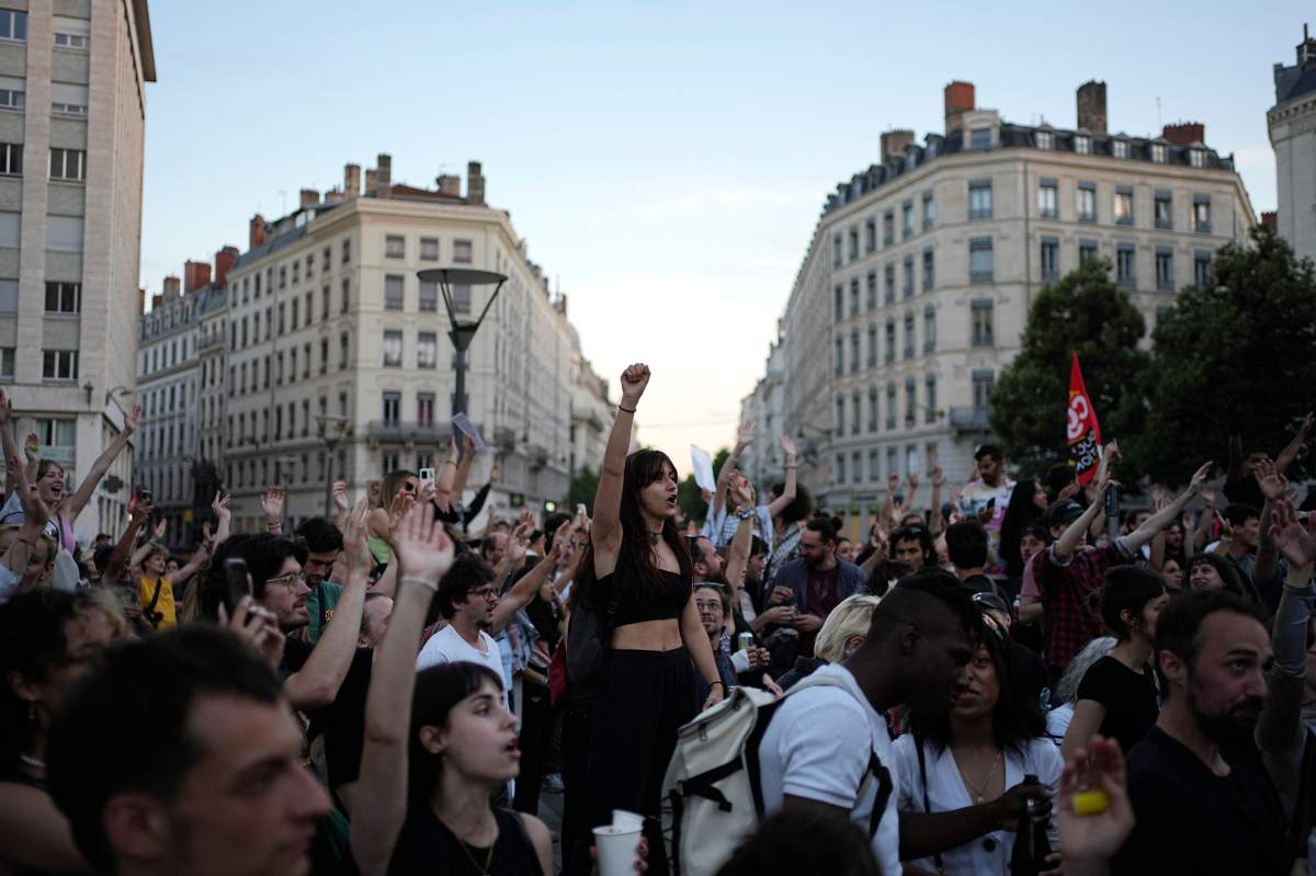 People stand in a square as they react to projected results after the second round of the legislative elections, in Lyon, central France, Sunday, July 7, 2024. Polls have closed in France, and polling projections say a coalition on the left that came together unexpectedly has won the most parliamentary seats in the pivotal runoff elections after a high turnout among voters.
