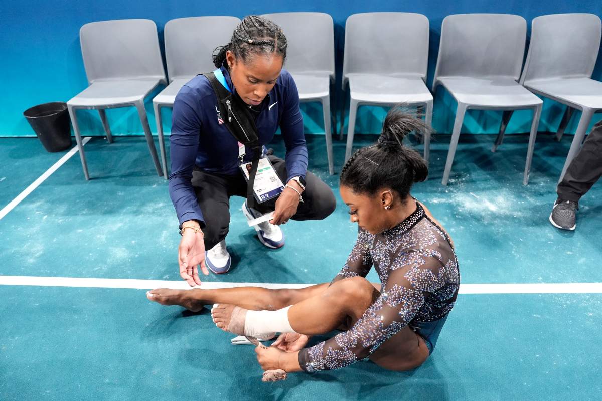 Simone Biles of the United States, has her ankle taped after competing on the uneven bars during a women's artistic gymnastics qualification round at Bercy Arena at the 2024 Summer Olympics, Sunday, July 28, 2024, in Paris, France.