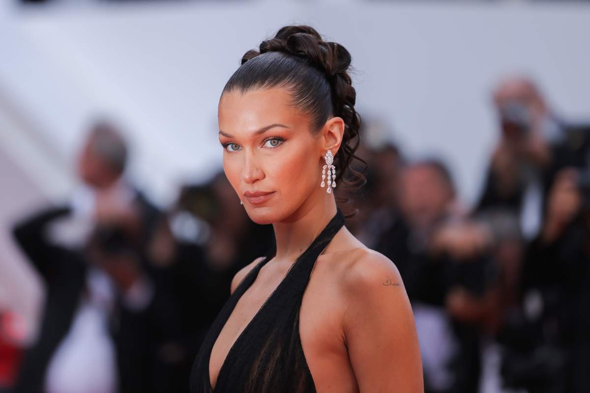 Bella Hadid in a black dress. Her hair is styled in an up-do.