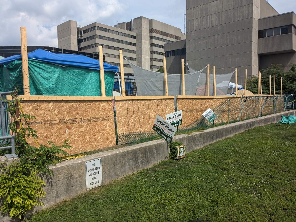 Plywood and tarps at the side of an encampment at a university.