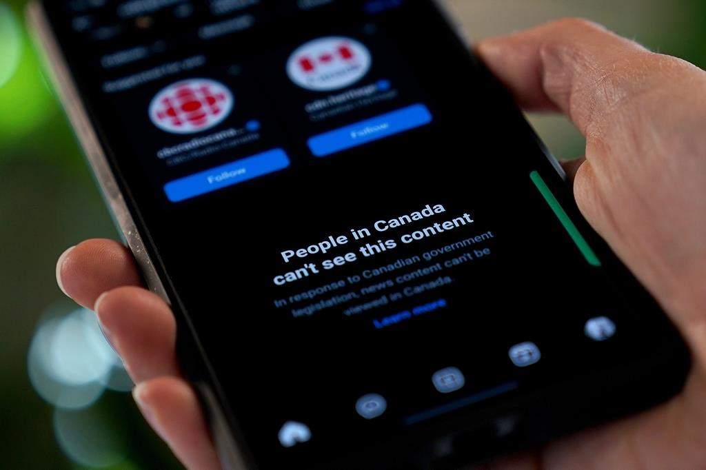 A smartphone showing Meta’s blocking of Canadian news content on their Instagram social media app is shown in a photo illustration, in Toronto, Aug. 1, 2024.