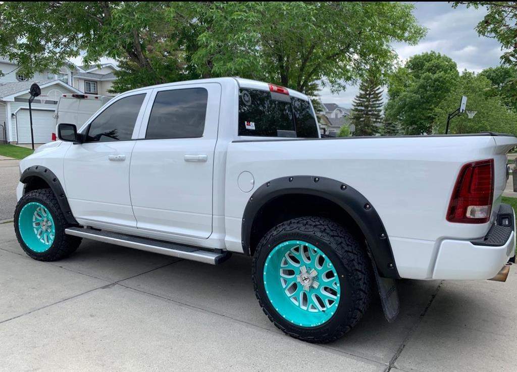 A white 2013 Dodge Ram with teal aftermarket rims and shell-shaped lugnuts is shown in this police handout photo.