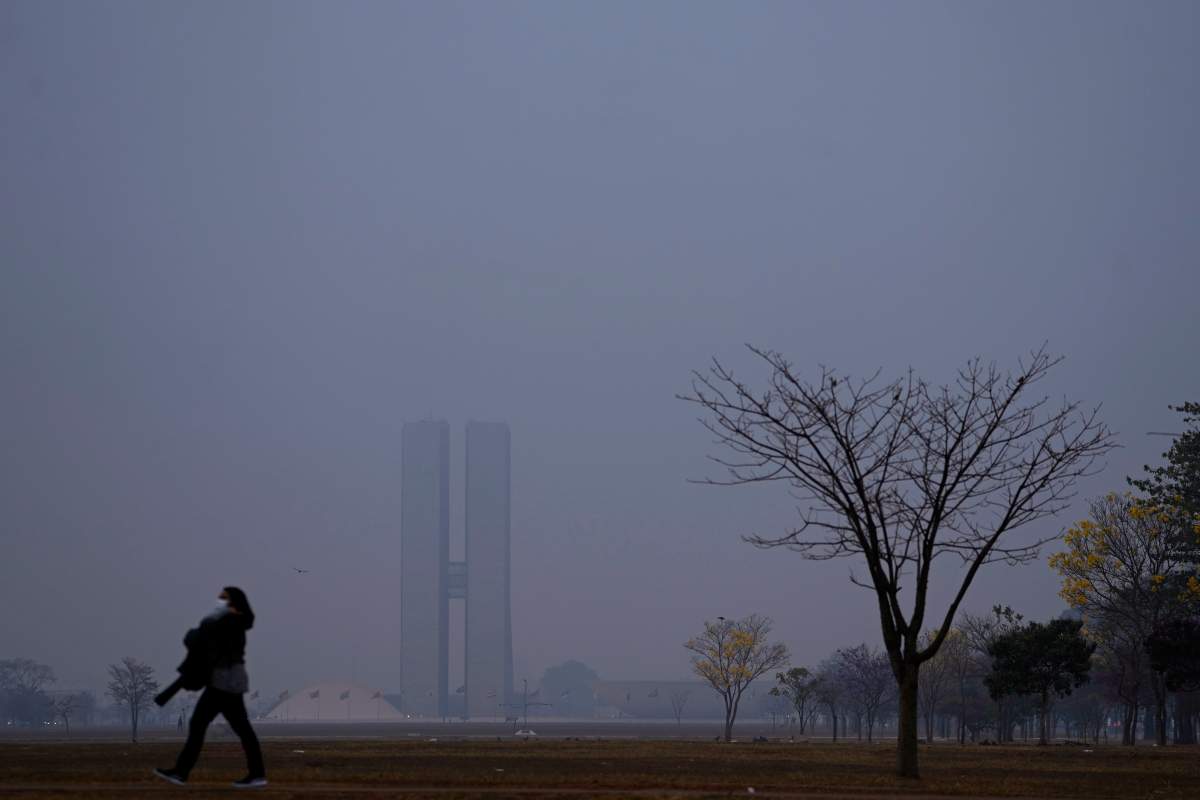The National Congress is barely visible through smoke from wildfires during dry weather in Brasilia, Brazil, early Monday, Aug. 26, 2024. (AP Photo/Eraldo Peres)