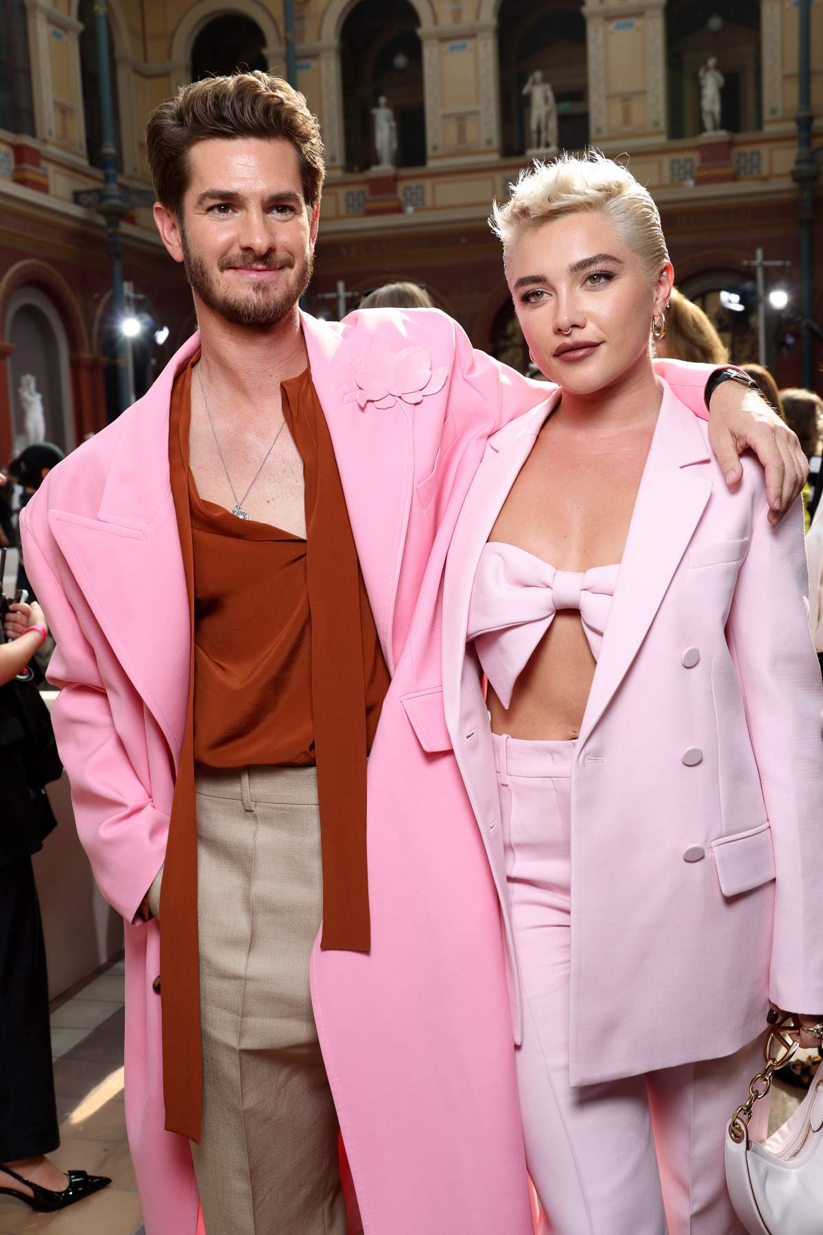 Andrew Garfield and Florence Pugh in pink clothing.