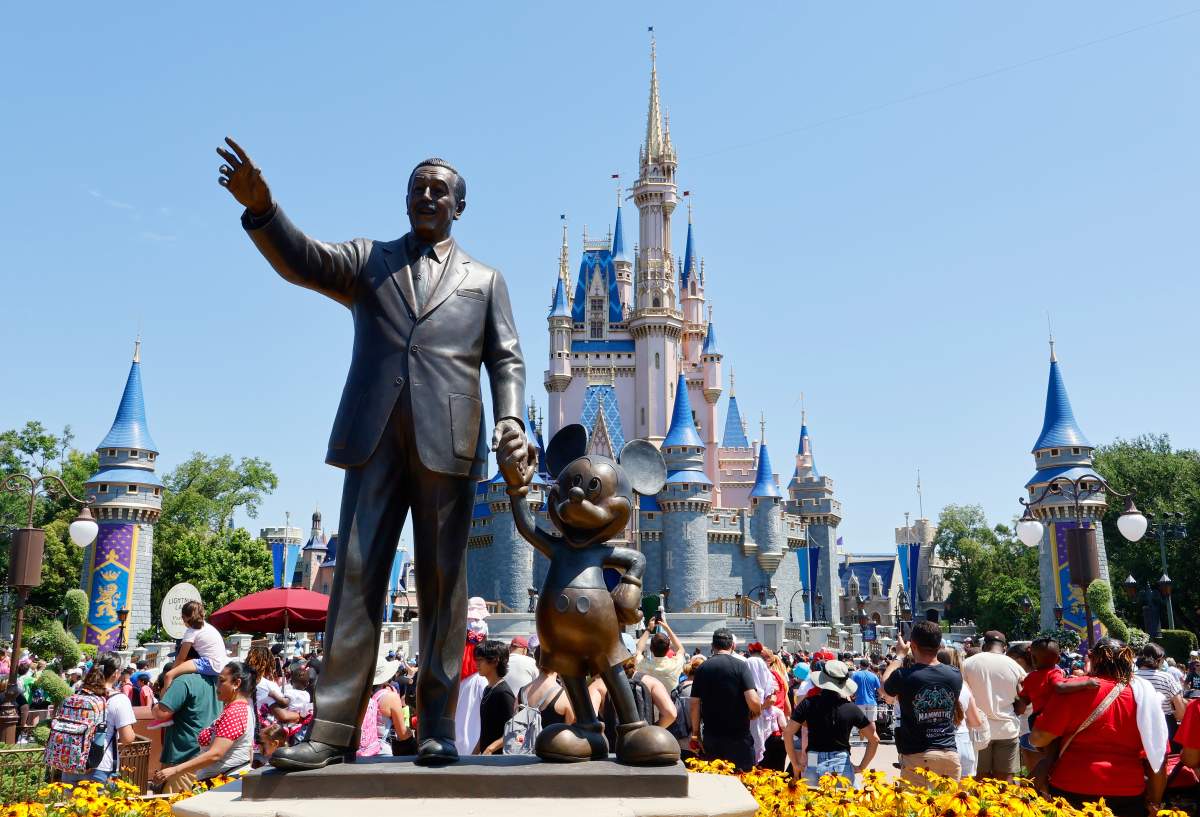 Walt Disney World. There is a statue of Walt Disney with Mickey in front of Cinderella's castle.
