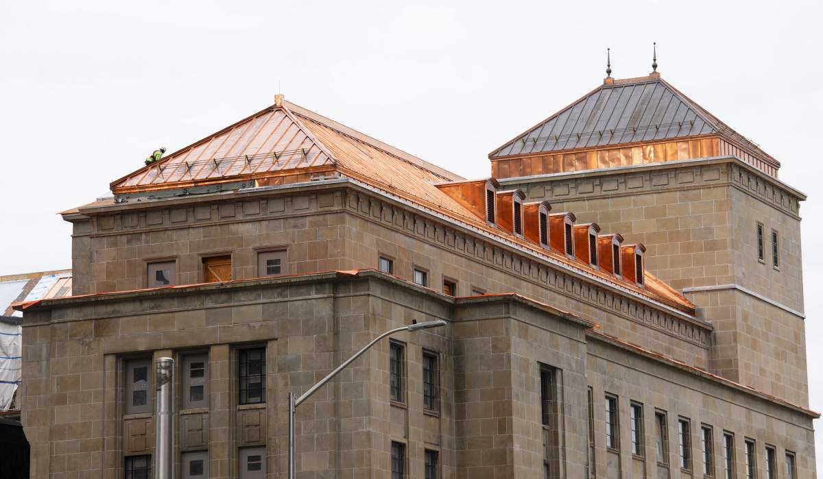 A construction worker is seen on the restored copper roof of the West Memorial Building in Ottawa on October 19, 2022. THE CANADIAN PRESS/Sean Kilpatrick
