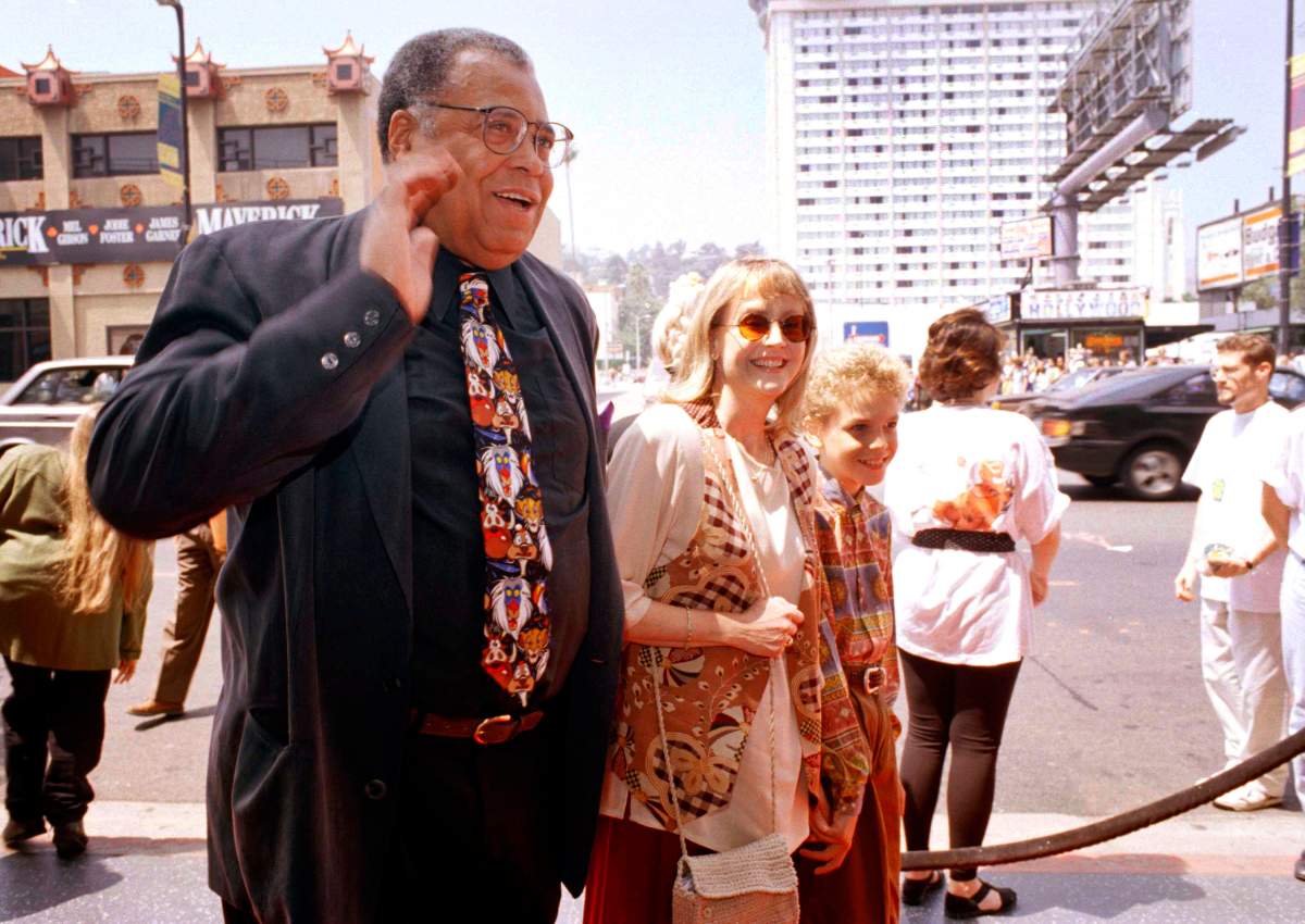 FILE – James Earl Jones, left, greets the press along with his wife Cecilia, center, and son Flynn, right, at the premiere of “The Lion King” in Los Angeles, June 12, 1994. Jones, who overcame racial prejudice and a severe stutter to become a celebrated icon of stage and screen has died at age 93, Monday, Sept. 9, 2024. (AP Photo/Tara Farrell, File)