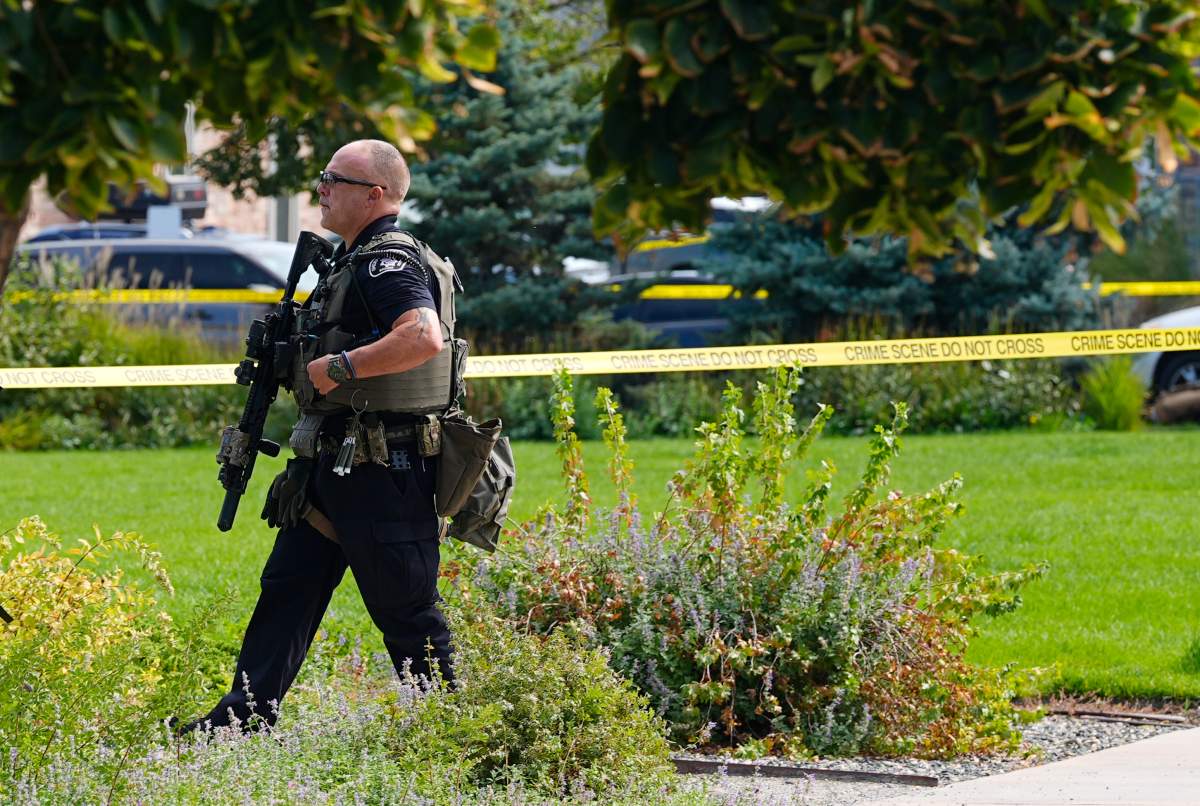 An armed law enforcement officer walks through a park following a shooting at an apartment complex Thursday morning, Sept. 12, 2024, in Broomfield, Colo., a suburb of Denver. (AP Photo/David Zalubowski)