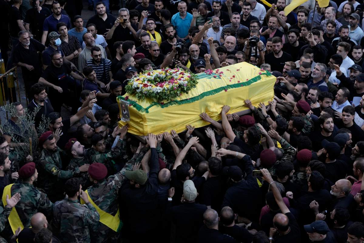Hezbollah fighters carry one of the coffins of four fallen comrades who were killed Tuesday after their handheld pagers exploded, during their funeral procession in the southern suburb of Beirut, Lebanon, Wednesday, Sept. 18, 2024. (AP Photo/Bilal Hussein)