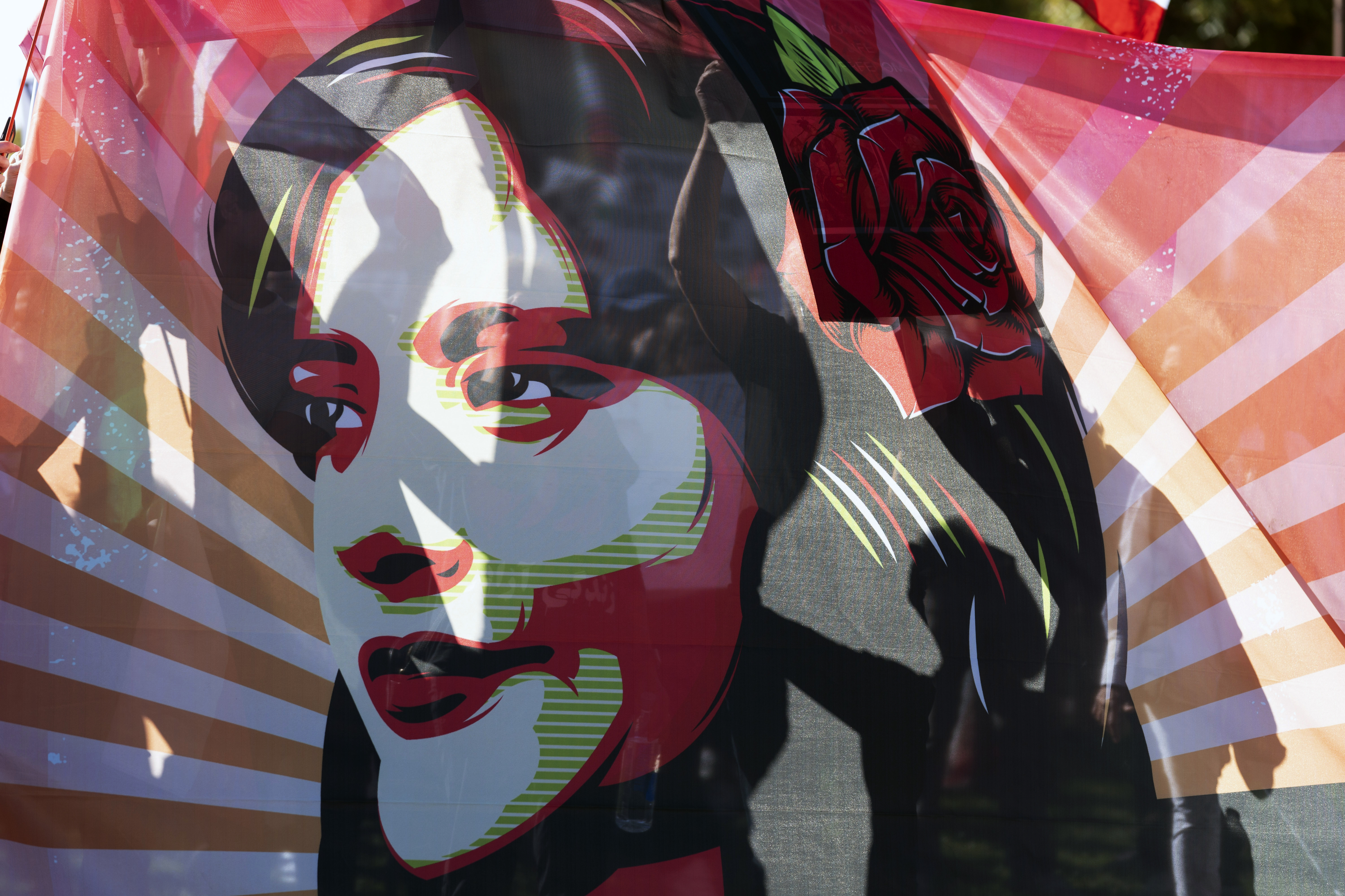 Image of Mahsa Amini on flag at rally against Iranian regime, in Washington, D.C. Oct. 22, 2022. (AP Photo/Jose Luis Magana).