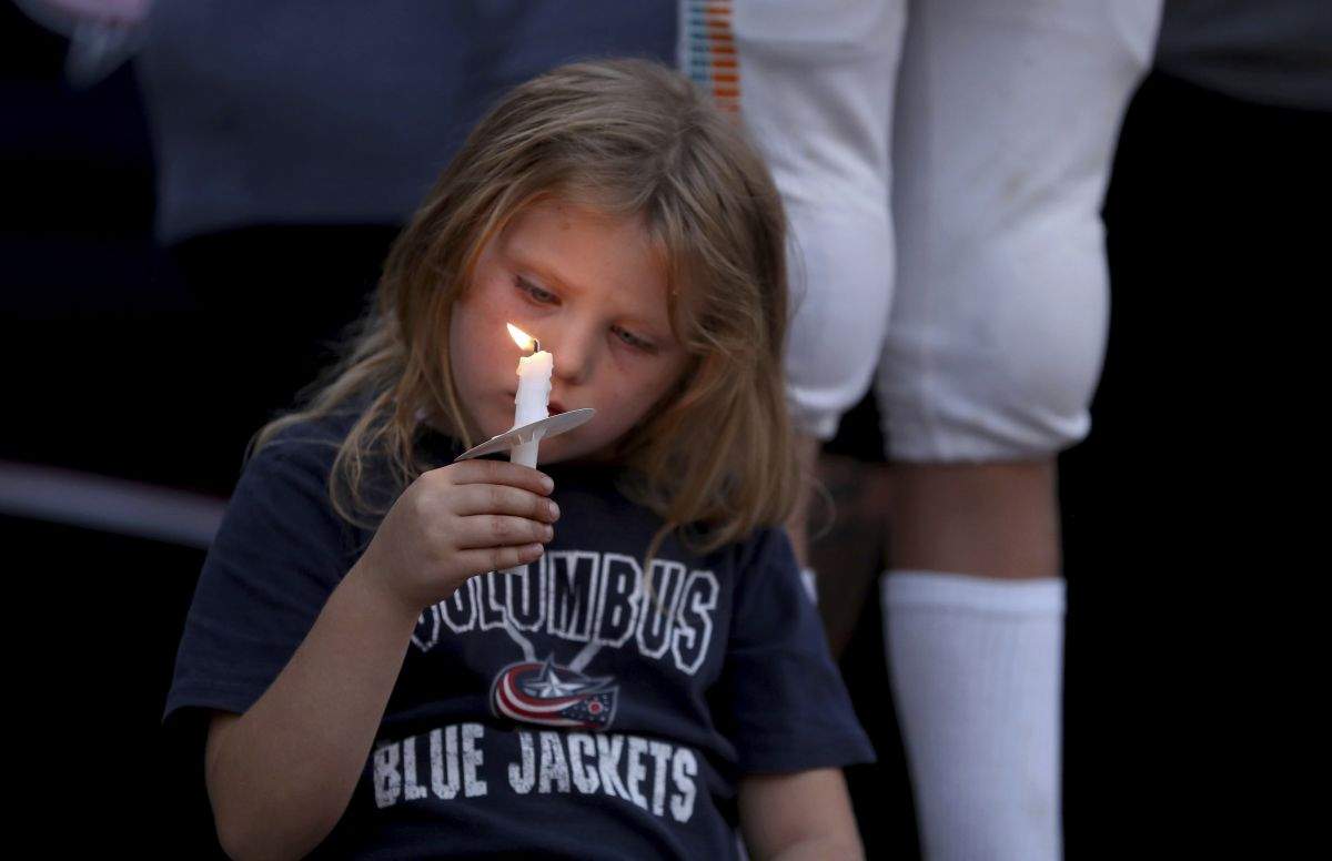 Columbus Blue Jackets fan Scarlett Well, has a moment of silence during the candlelight vigil to honour of Blue Jackets hockey player Johnny Gaudreau, outside of Nationwide Arena in Columbus, Ohio, Wednesday, Sept. 4, 2024. Gaudreau and his brother Matthew were killed by a motor vehicle last week while riding bicycles.