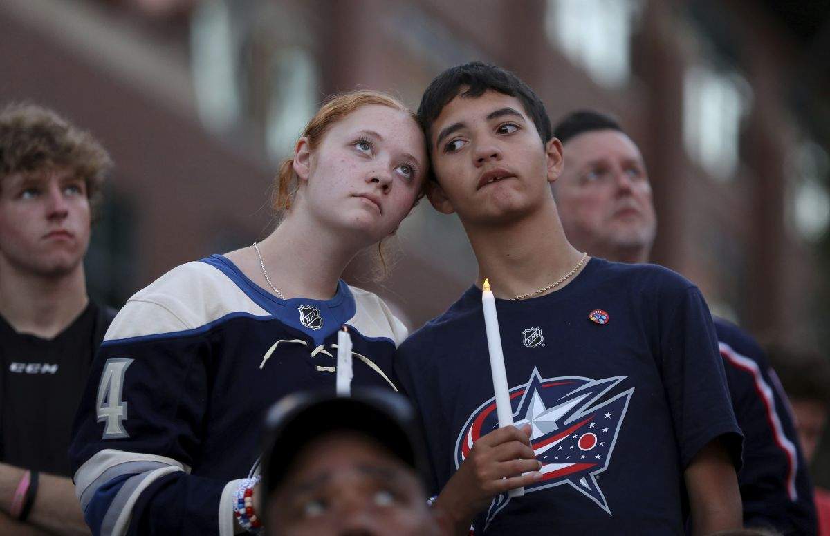 Blue Jackets fans Gianna,left, and Elijah Willis, have a moment of silence during the candlelight vigil to honour Columbus Blue Jackets hockey player Johnny Gaudreau, outside of Nationwide Arena in Columbus, Ohio, Wednesday, Sept. 4, 2024. Gaudreau and his brother Matthew were killed by a motor vehicle last week while riding bicycles.