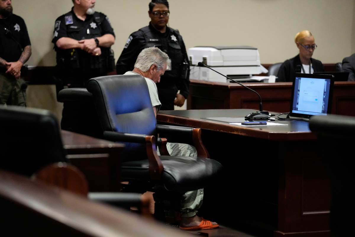 Colin Gray sits in the courtroom with his head hung behind a desk.