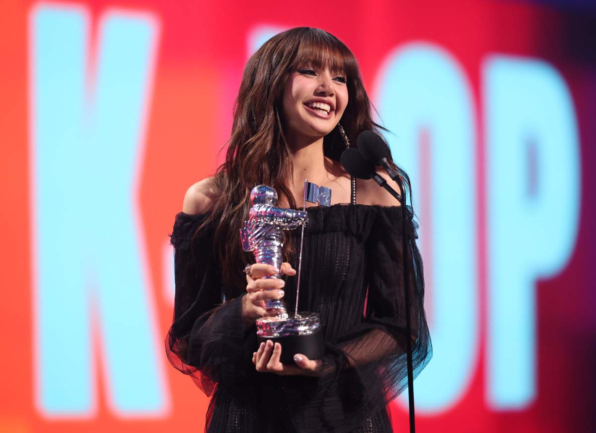 Lisa holding a moon man trophy.