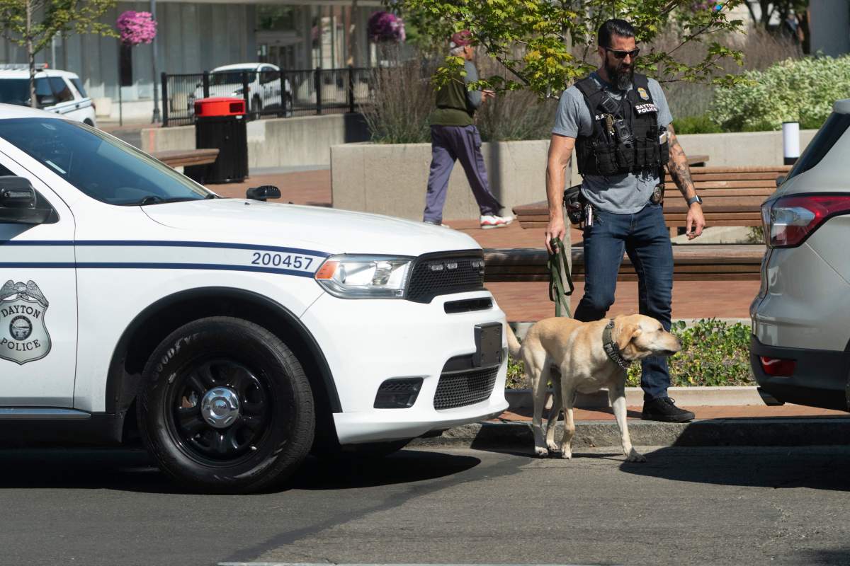 A Dayton police officer and his dog return to their vehicle after sweeping the Springfield City Hall grounds for explosives after bomb threats were made against buildings earlier in the day in Springfield, Ohio on September 12, 2024.