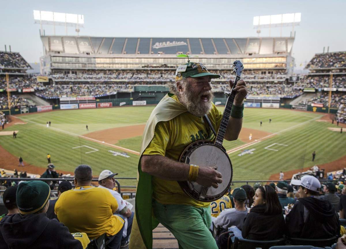 FILE - Oakland Athletics fan "Banjo Man" (aka Stacy Samuels) plays for the crowd in the fifth inning of Game 5 of an American League baseball division series between the Oakland Athletics and the Detroit Tigers in Oakland, Calif., Thursday, Oct. 10, 2013.