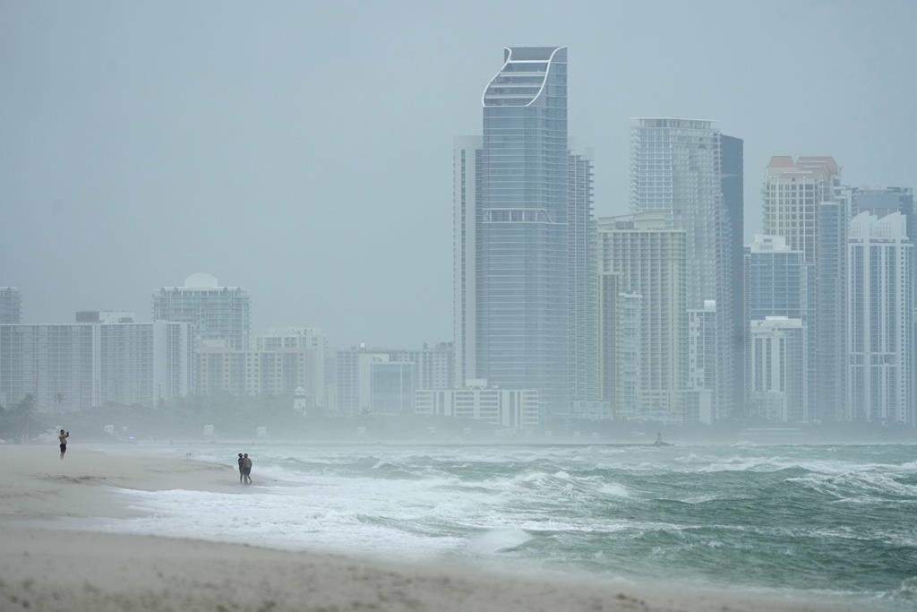 The city of Sunny Isles Beach, Fla., is seen from Surfside, Fla., as the outer bands of Hurricane Milton kick up the sand, Wednesday, Oct. 9, 2024.