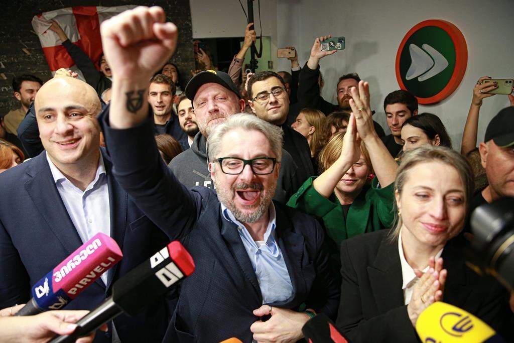 From left, Nika Melia, Nika Gvaramia, leaders of Coalition for Changes, and Nana Malashkhia, who leads the Coalition for Change parliament list, react while talking to journalists at coalition's headquarters after polls closing at the parliamentary election in Tbilisi, Georgia, Saturday, Oct. 26, 2024. 