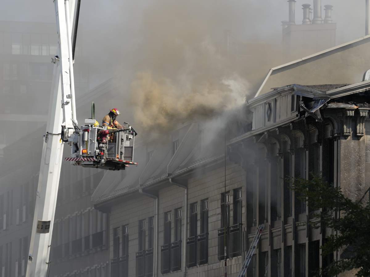 A firefighter battles a blaze in Old Montreal on Friday, Oct.4, 2024. Montreal police are investigating a major fire that broke out early this morning in a century-old building in Old Montreal.
