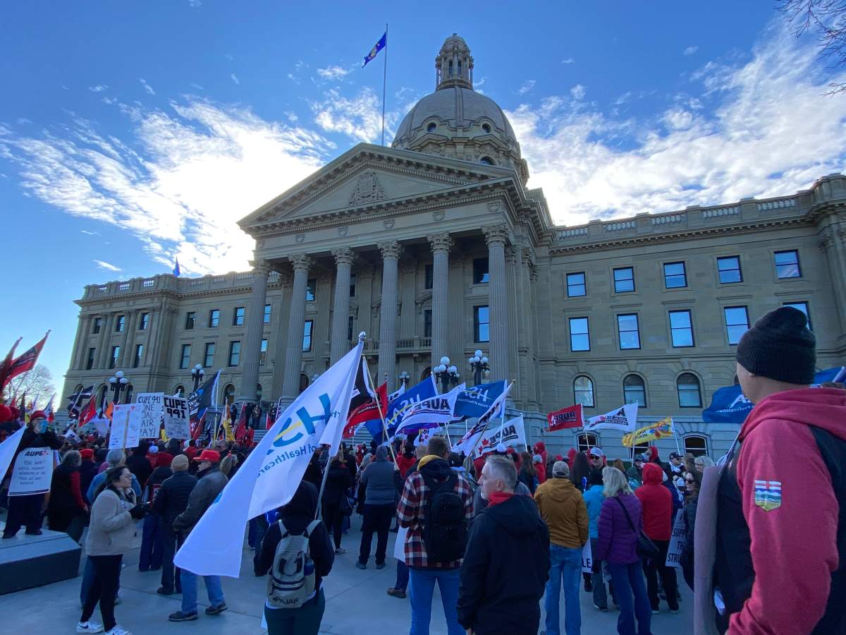 Protesters stand in front of the Alberta legislature on Oct. 24, 2024 to voice their opposition to the provincial government mandating the use of a dispute inquiry board in an ongoing labour dispute between school support workers and the Edmonton Public School Board.