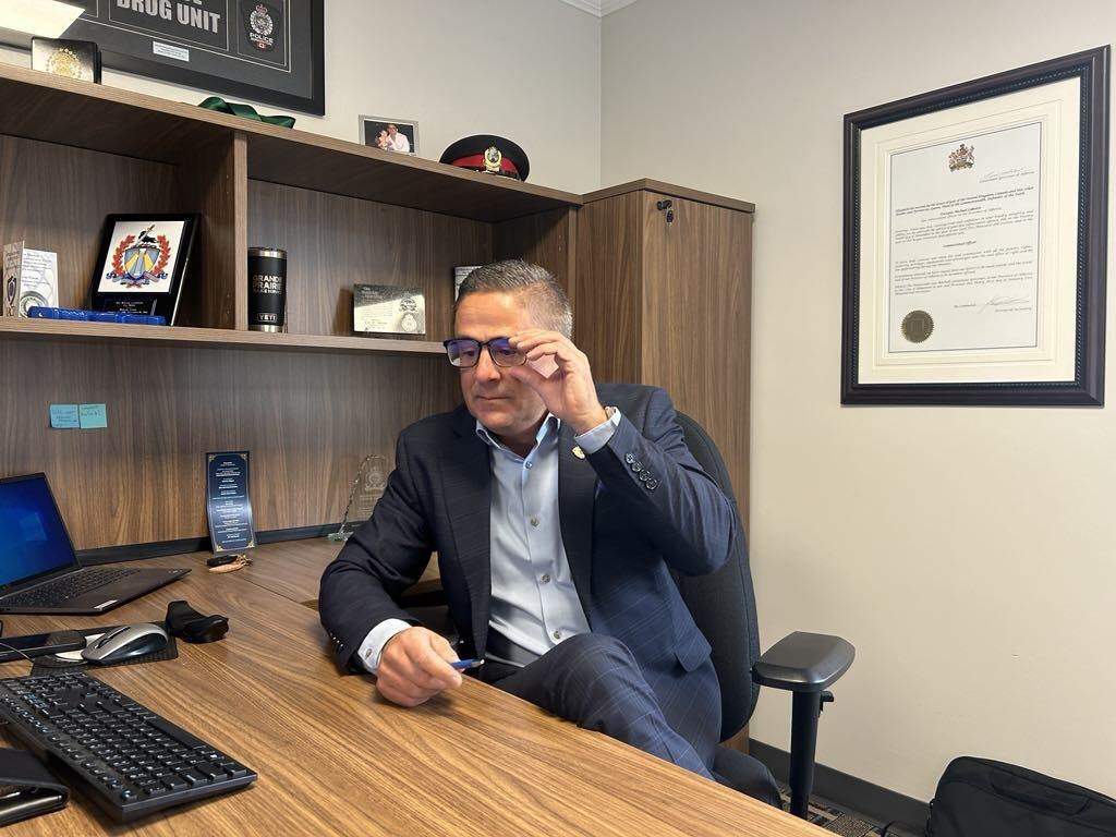 Grande Prairie Police Service Chief Dwayne Lakusta adjusts his glasses during an interview with The Canadian Press in his office in Grande Prairie, Alta., Wednesday, Oct. 2, 2024. 
