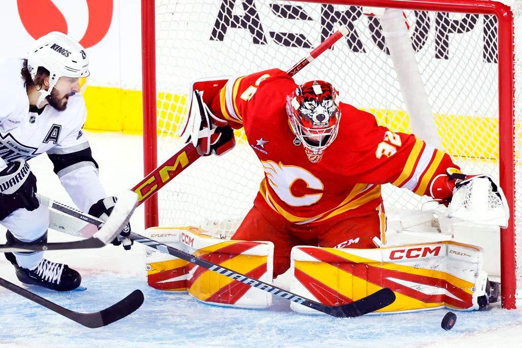 Calgary Flames goalie Dustin Wolf (32) stops a shot by Los Angeles Kings' Phillip Danault during third period NHL hockey action in Calgary, Alta., Monday, Nov. 11, 2024.