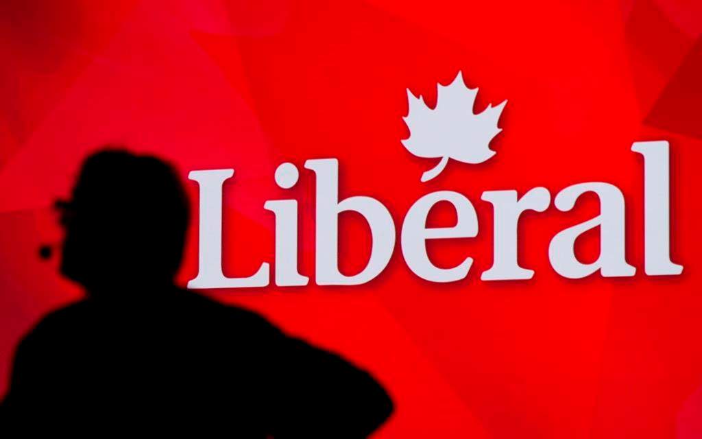 A Liberal Party of Canada logo is shown on a giant screen as a technician looks on during day one of the party's biennial convention in Montreal on Feb. 20, 2014.