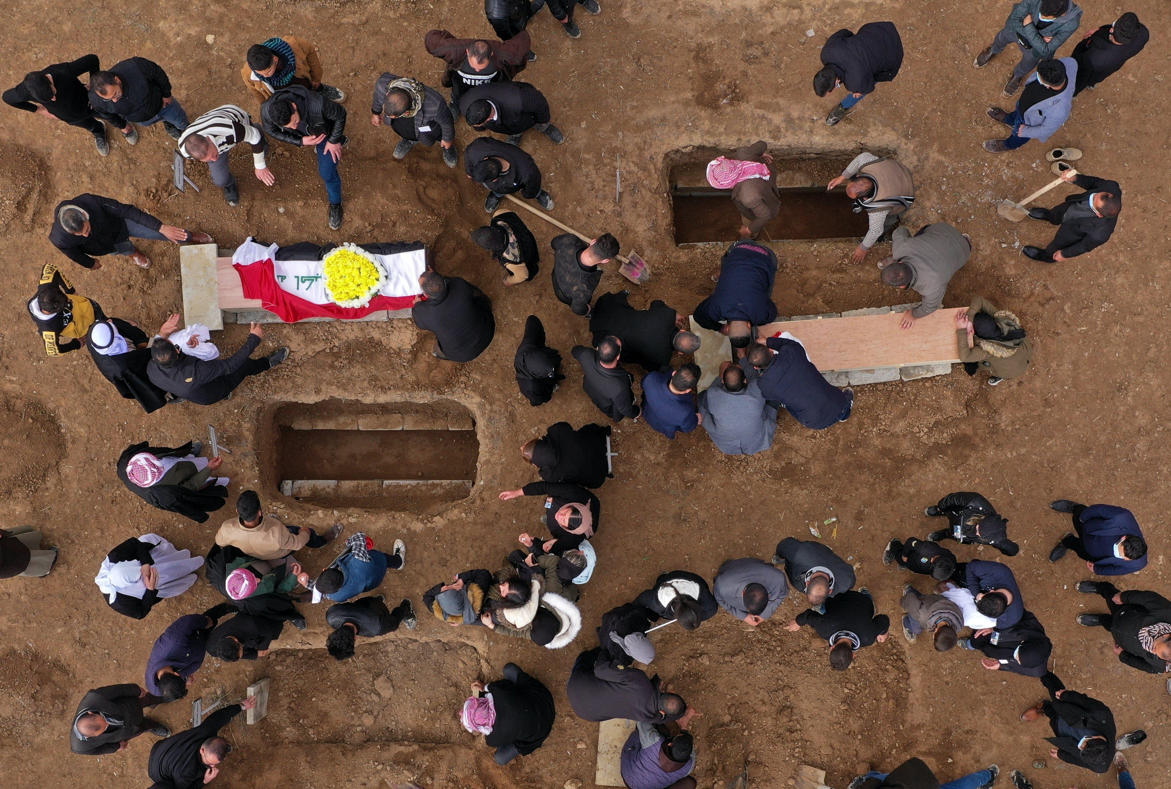 Mourners bury the remains of Yazidi victims in a cemetery in Kocho, Iraq. (AP Photo/Farid Abdulwahed)