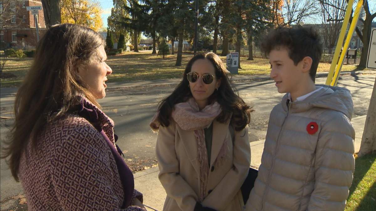 Dr. Samara Zavalkoff and her son Charlie Shein speak to a Montreal West town councillor about road safety.