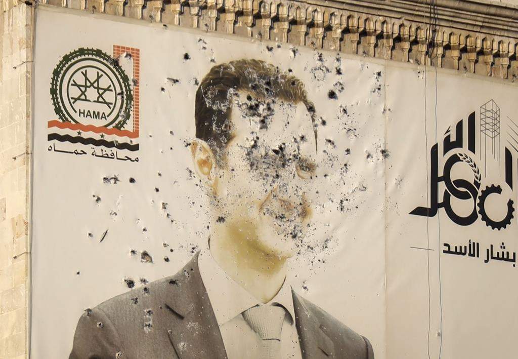 An image of Syrian President Bashar Assad, riddled with bullets, is seen on the facade of the provincial government office in the aftermath of the opposition's takeover of Hama, Syria, Friday, Dec. 6, 2024.
