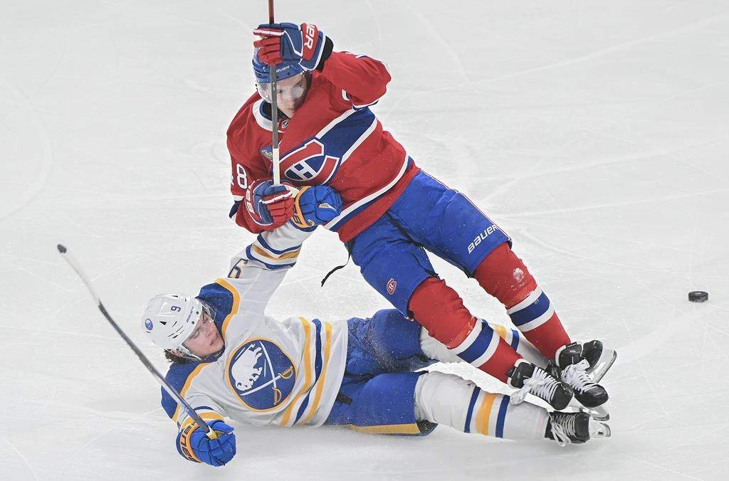 Montreal Canadiens' Lane Hutson (48) is tripped by Buffalo Sabres' Zach Benson (9) during first period NHL hockey action in Montreal, Tuesday, Dec. 17, 2024.