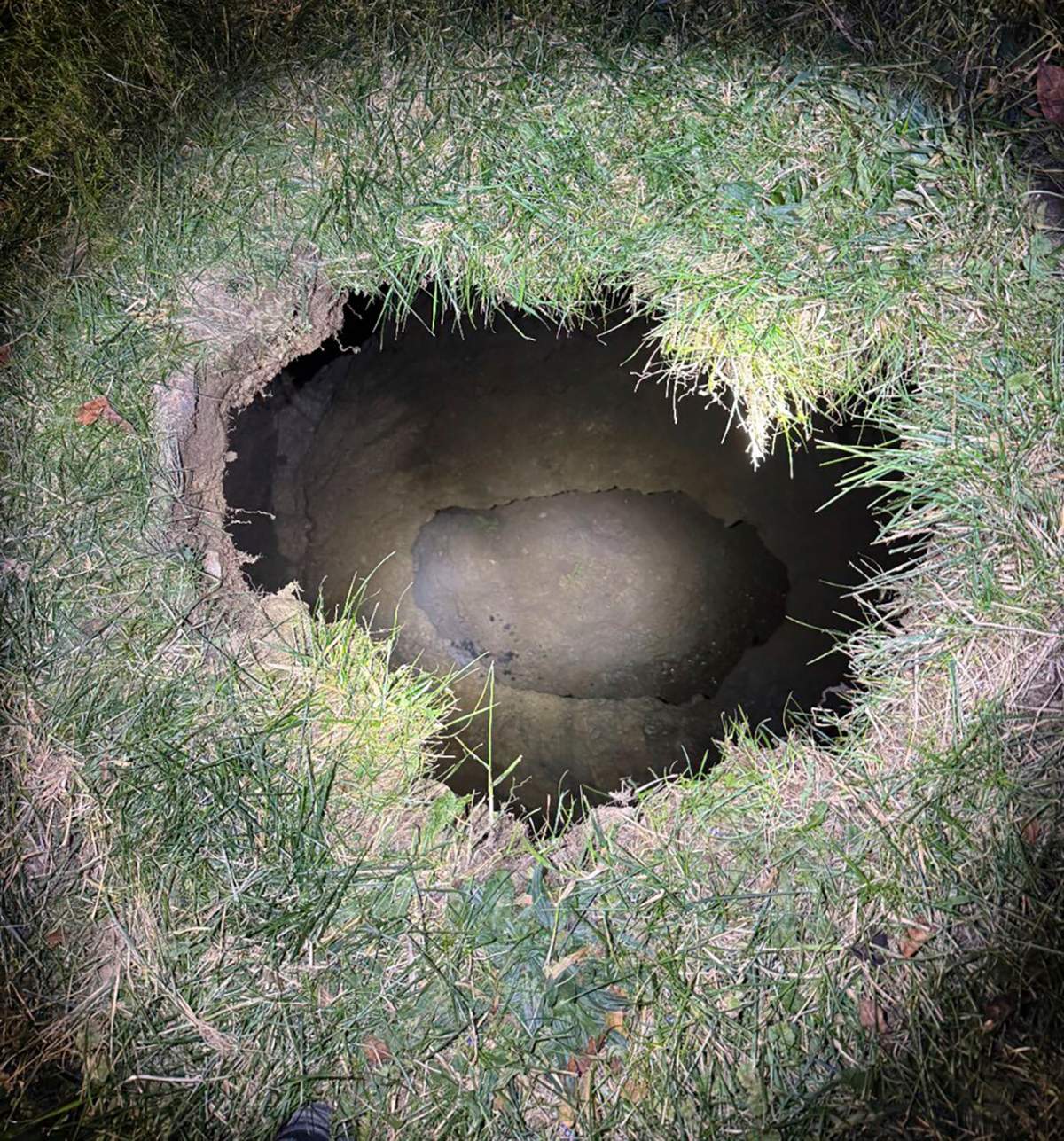 This Dec. 3, 2024 image, provided by the Pennsylvania State Police, shows the top of a sinkhole in the village of Marguerite, Pa., where rescuers were searching for a woman who disappeared.