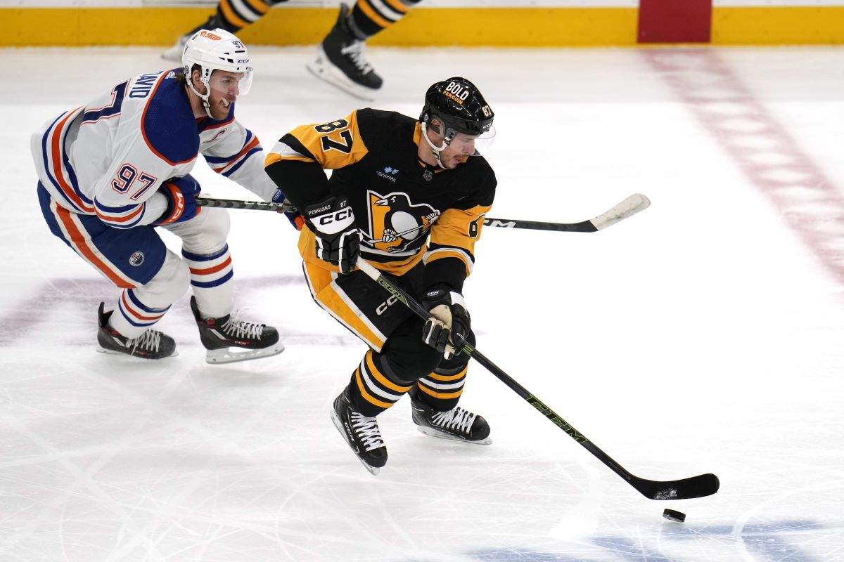 Pittsburgh Penguins' Sidney Crosby (87) skates past Edmonton Oilers' Connor McDavid during the first period of an NHL hockey game in Pittsburgh, Sunday, March 10, 2024.