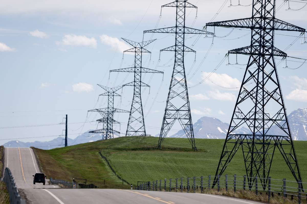 Power transmission lines are seen with the Rocky Mountains in the background near Pincher Creek, Alta., Thursday, June 6, 2024.
