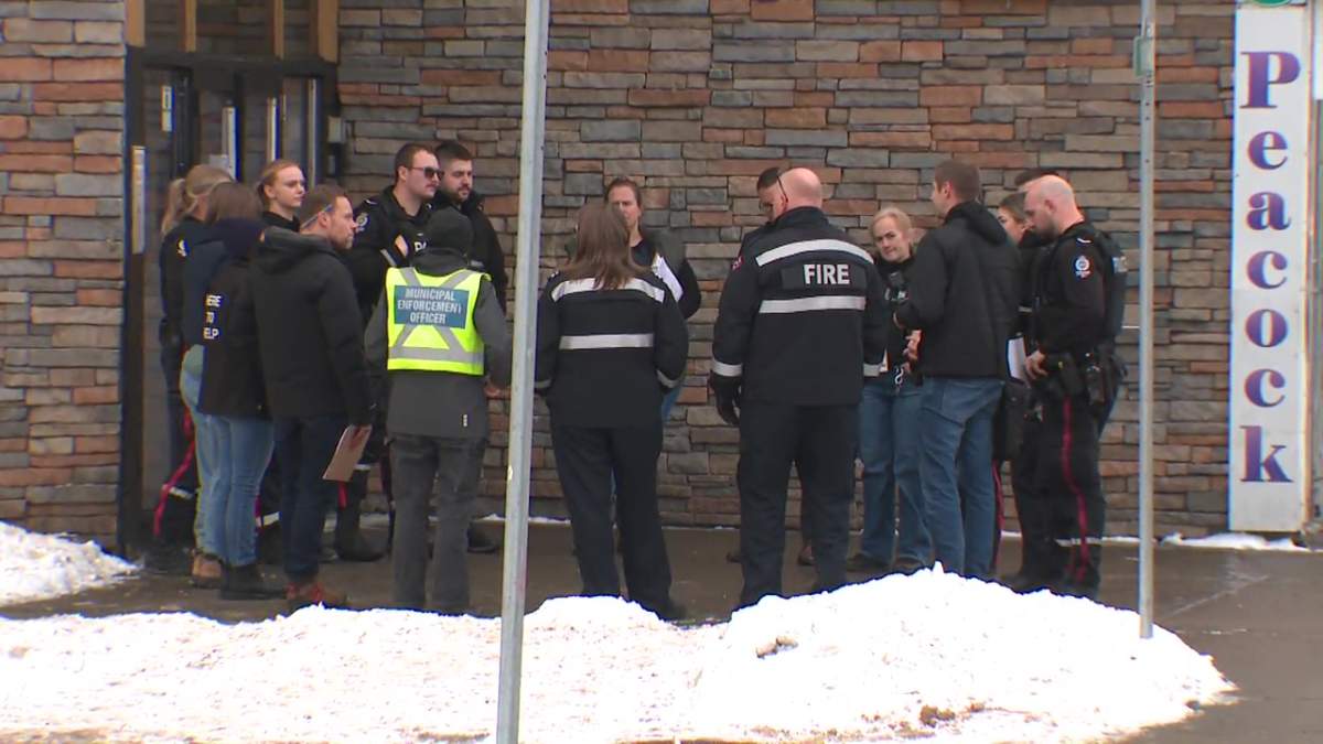 Police and other investigators at an apartment in central Edmonton (10603 107 Ave.) where a security guard was killed in December 2024.