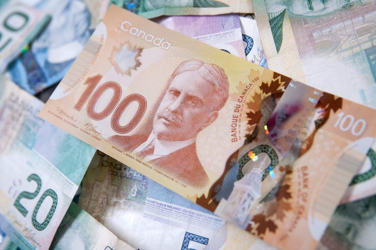 Pile of Canadian bills with one hundred dollars on top