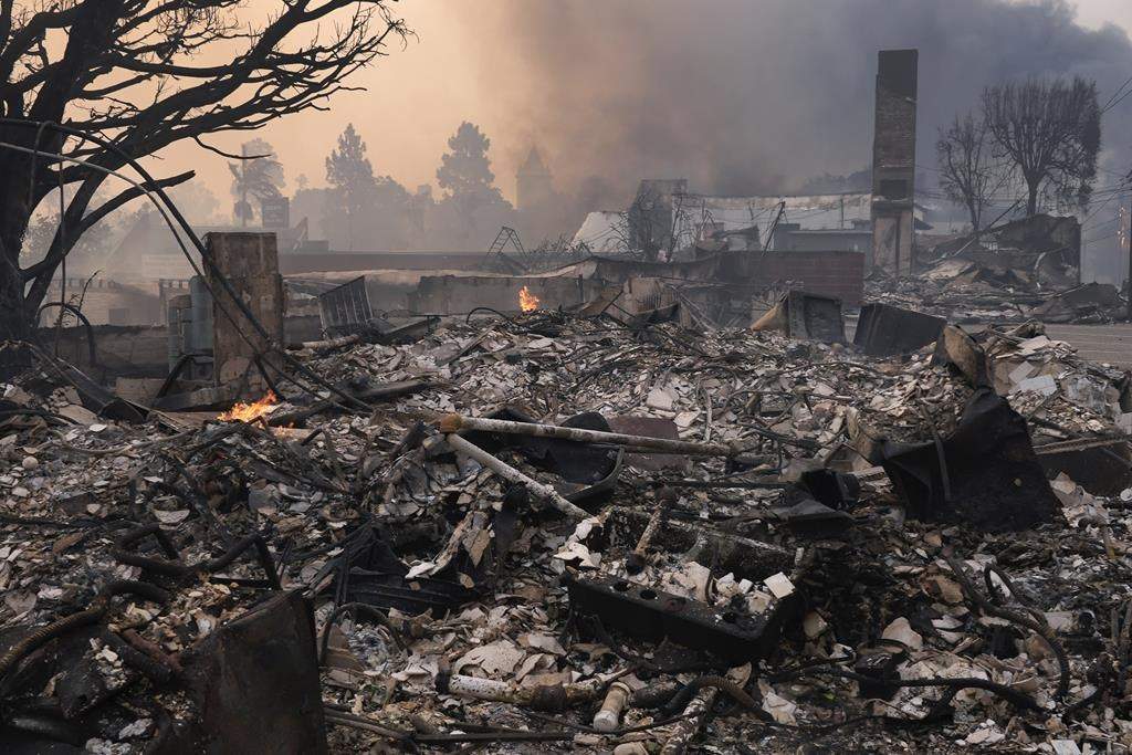The Palisades Fire ravages a neighborhood amid high winds in the Pacific Palisades neighborhood of Los Angeles, Wednesday, Jan. 8, 2025.