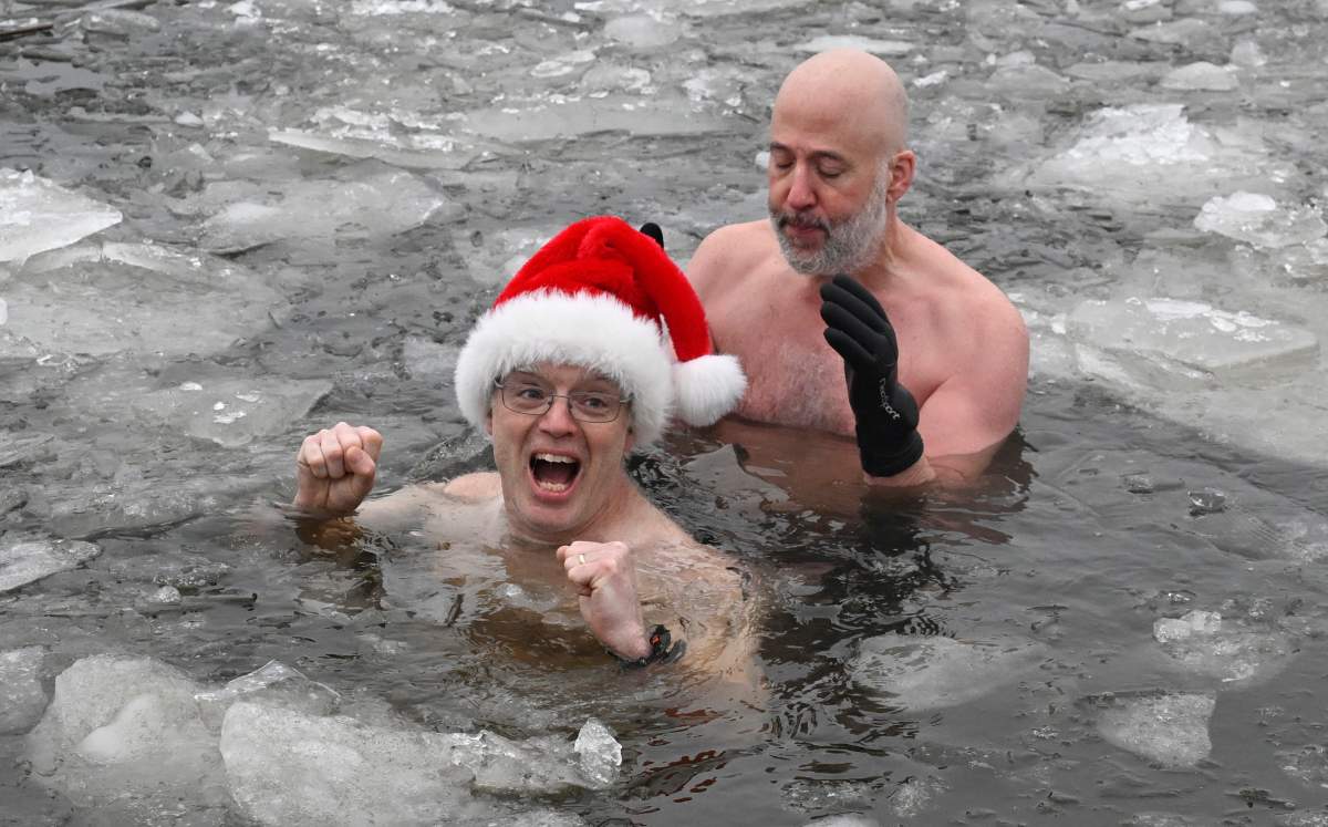 Local resident Simon Plourde reacts to his first swim into the icy water of the St.Lawrence river for a Polar Bear swim on New Year’s Day in Quebec City, Wednesday, Jan. 1, 2025. Organizer Francis Vachon is seen at right. THE CANADIAN PRESS/Jacques Boissinot