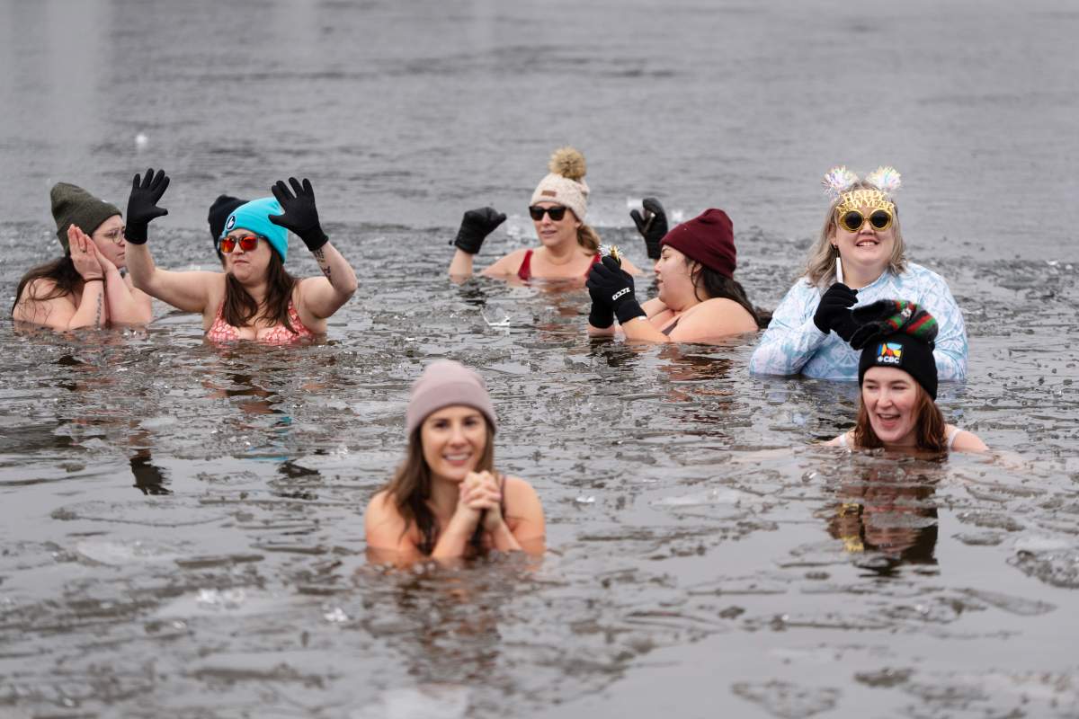 People swim in the ice-filled water in Lake Banook during the annual polar bear swim on New Year’s Day in Dartmouth, N.S., Wednesday, Jan. 1, 2025. THE CANADIAN PRESS/Darren Calabrese