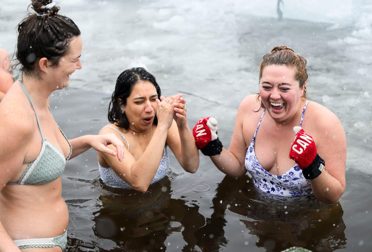 Grace McCreary, right,Abeer Shahid, centre, andVeronika Kelly, left, dip in the waters of Gatineau Park’s Meech Lake in Chelsea, Que., during a polar bear dip on New Year’s Day, Wednesday, Jan. 1, 2025. THE CANADIAN PRESS/Justin Tang