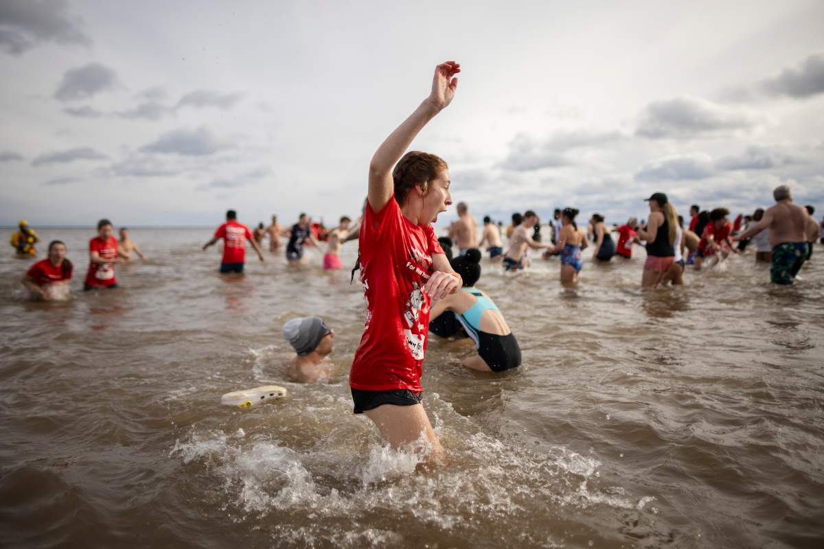 People participate in the annual polar bear dip on New Year’s Day in Oakville, Ont., Wednesday, Jan. 1, 2025. THE CANADIAN PRESS/Nick Iwanyshyn