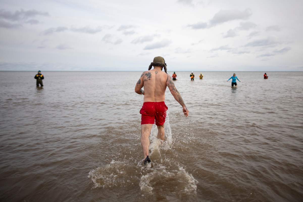 People participate in the annual polar bear dip on New Year’s Day in Oakville, Ont., Wednesday, Jan. 1, 2025. THE CANADIAN PRESS/Nick Iwanyshyn