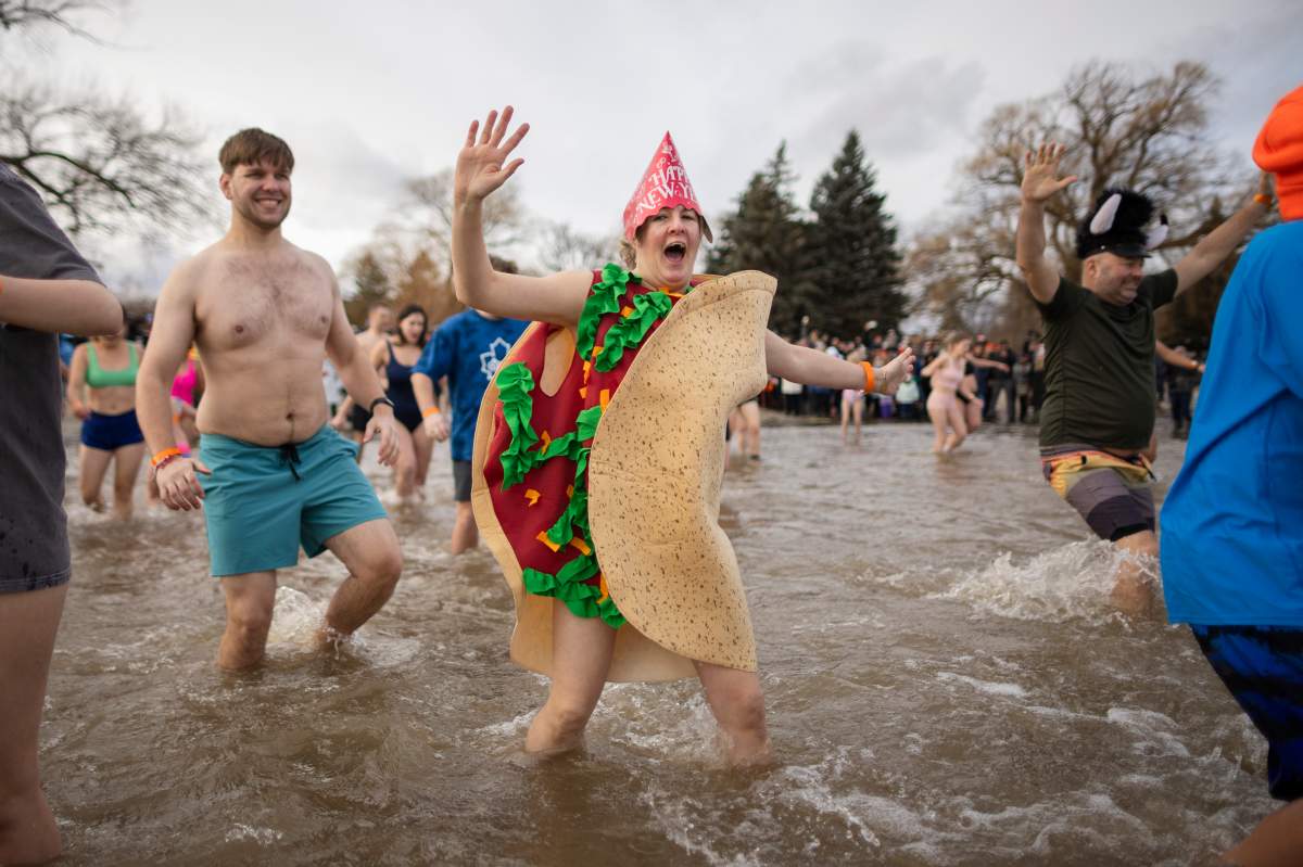 People participate in the annual polar bear dip on New Year’s Day in Oakville, Ont., Wednesday, Jan. 1, 2025. THE CANADIAN PRESS/Nick Iwanyshyn