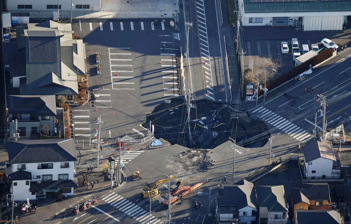 Police officers and rescue members prepare for a rescue mission in Yashio City, northeast of Tokyo, Thursday, Jan. 30, 2025, two days after a truck fell into the sinkhole made on a street Tuesday.