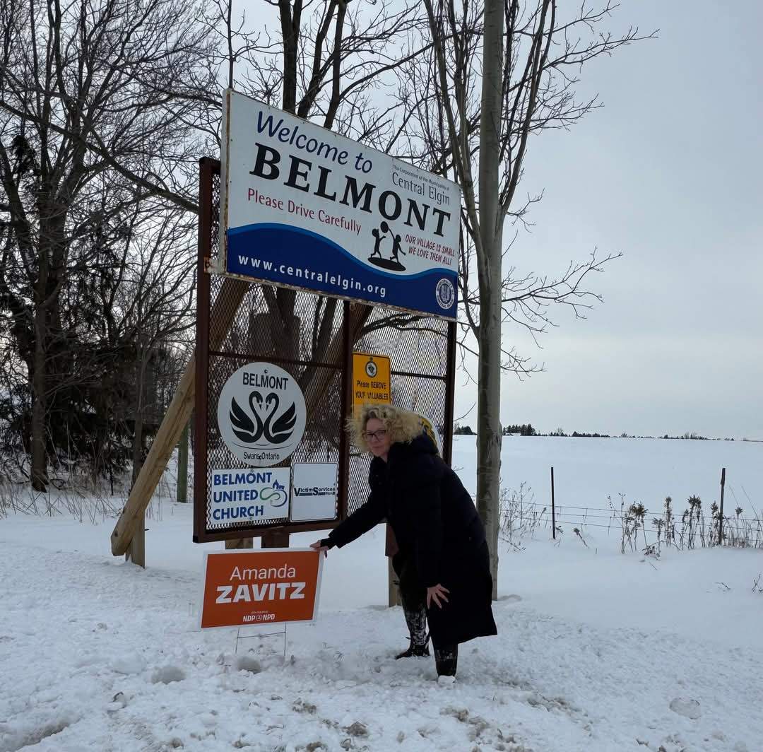 Amanda Zavitz places an election sign.
