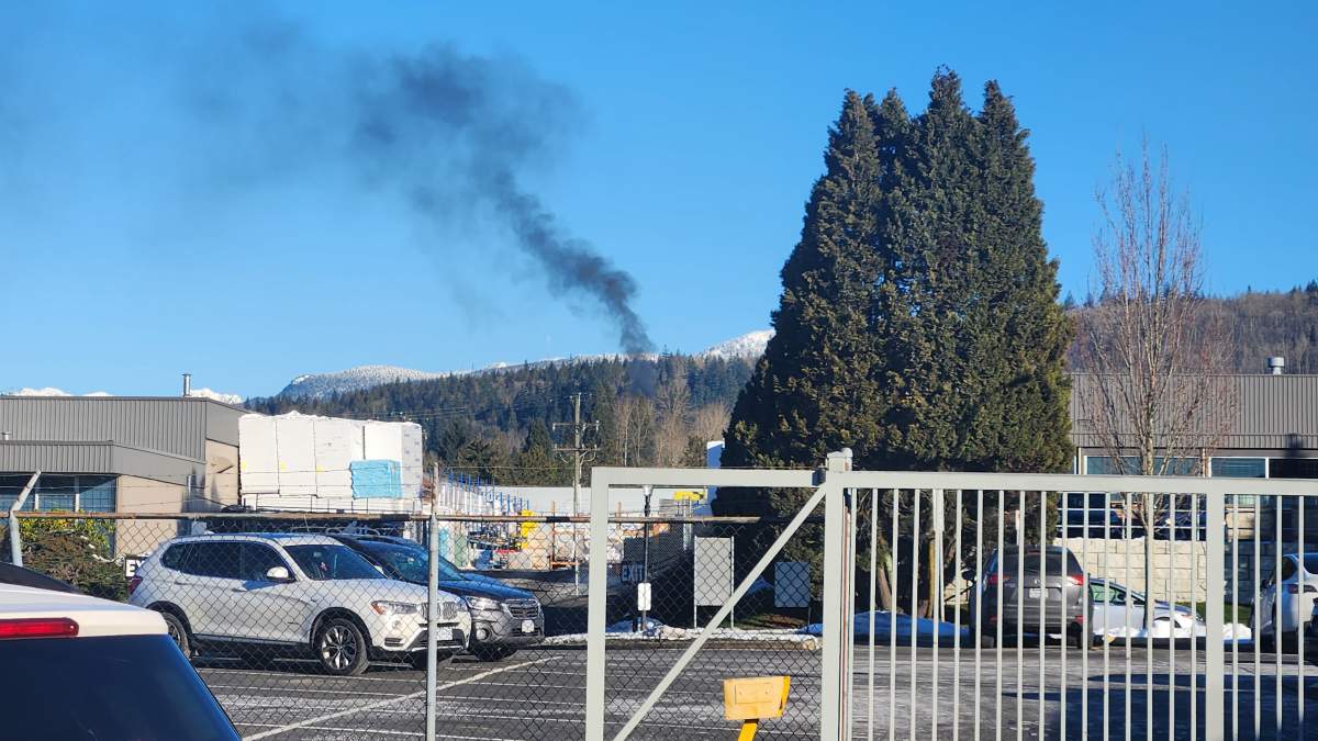 A plume of smoke can be seen rising from the location of a car fire in Burnaby that may be connected with a shooting in Coquitlam on Monday morning.
